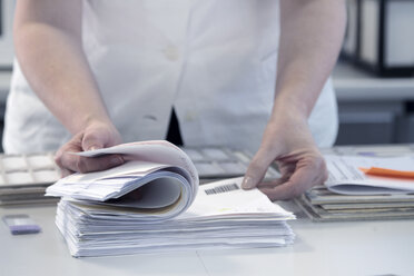 Female scientist checking through paperwork - CUF34507