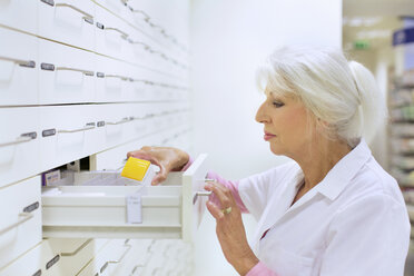 Female pharmacist searching for medicine for prescription - CUF34536