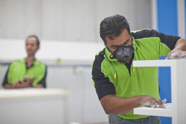 Mann beim Schleifen von Holzprodukten in einer Schreinerwerkstatt - CUF34575