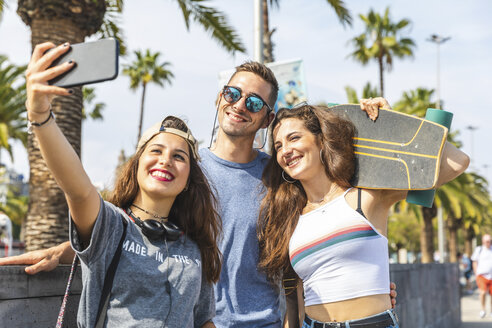 Drei glückliche Freunde mit Skateboard machen ein Selfie - WPEF00455