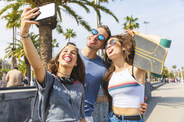Three playful friends with skateboard taking a selfie - WPEF00456