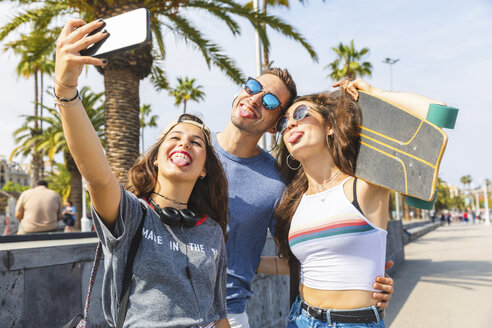 Drei verspielte Freunde mit Skateboard machen ein Selfie - WPEF00456