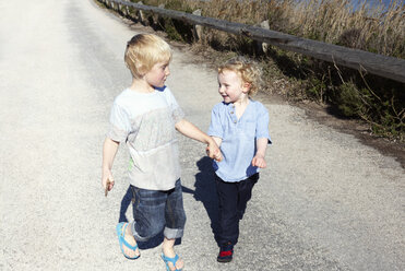 Brothers walking together, holding hands - CUF34628