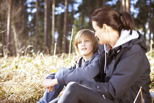 Reife Frau, die mit ihrem Sohn im Wald eine Pause einlegt - CUF34650