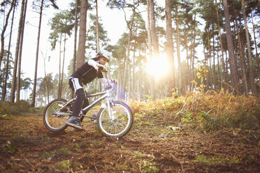 Junge fährt mit seinem BMX durch den Wald - CUF34654