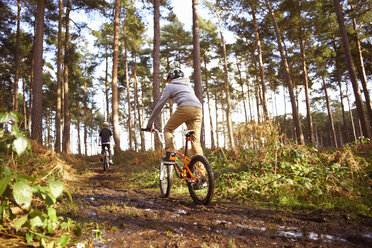 Zwillingsbrüder fahren BMX-Rennen im schlammigen Wald - CUF34659