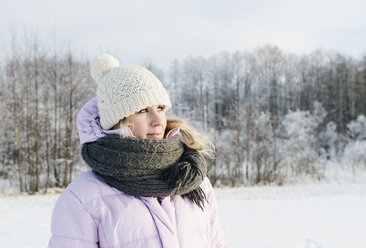 Mittlere erwachsene Frau in Winterkleidung auf einem verschneiten Feld - CUF34707