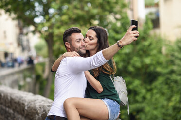 Couple in love in the city kissing and taking a selfie - JSMF00328