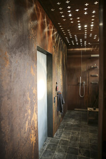 Modernes Bad mit Wandverkleidung aus Cortenstahl und Lichteffekten an der Decke - REAF00334