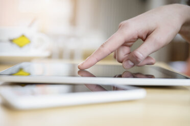 Close up of young woman's hand using touchscreen on digital tablet - CUF34722