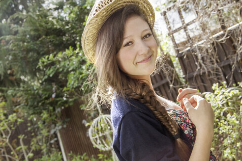 Porträt eines Teenagers mit Strohhut im Garten - CUF34724