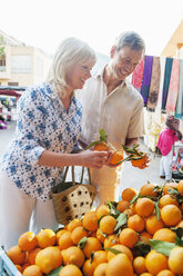 Ehepaar wählt Orangen auf dem Markt aus, Mallorca, Spanien - CUF34781