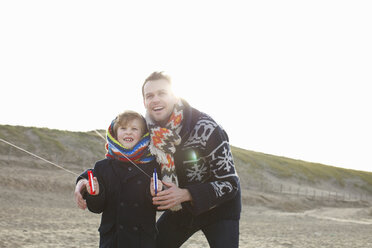 Erwachsener Mann lässt mit seinem Sohn am Strand einen Drachen steigen, Bloemendaal aan Zee, Niederlande - CUF34795