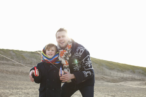 Erwachsener Mann lässt mit seinem Sohn am Strand einen Drachen steigen, Bloemendaal aan Zee, Niederlande - CUF34795