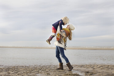 Mittlere erwachsene Frau hebt Tochter am Strand hoch, Bloemendaal aan Zee, Niederlande - CUF34800