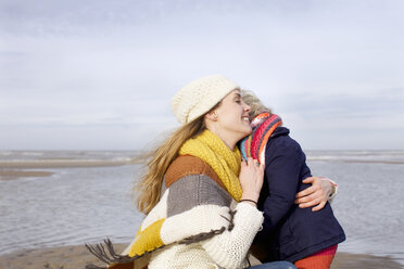 Mittlere erwachsene Frau, die ihre Tochter am Strand umarmt, Bloemendaal aan Zee, Niederlande - CUF34801