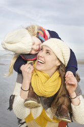 Mid adult woman carrying daughter on shoulders at beach, Bloemendaal aan Zee, Netherlands - CUF34803