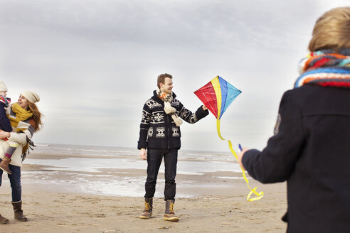 Erwachsene Eltern mit Sohn und Tochter spielen mit einem Drachen am Strand, Bloemendaal aan Zee, Niederlande - CUF34805