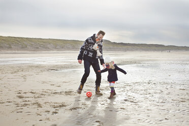 Mittelgroßer Mann mit Tochter spielt Fußball am Strand, Bloemendaal aan Zee, Niederlande - CUF34807