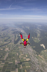 Female skydiver free falling upside down over Grenchen, Berne, Switzerland - CUF34817