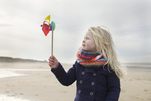 Porträt eines dreijährigen Mädchens mit Papierwindmühle am Strand, Bloemendaal aan Zee, Niederlande - CUF34821