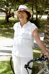 Portrait of senior woman and with bicycle in park - CUF34855