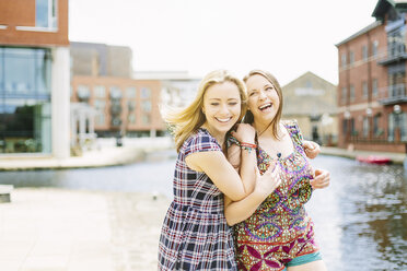 Friends fooling around by canal, Leeds, England - CUF34872