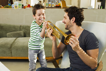 Vater ermutigt jungen Sohn beim Trompetespielen - CUF35051