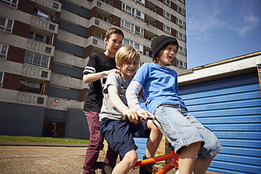 Junge, der zwei Freunde auf dem Fahrrad mitnimmt - CUF35161