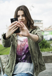 Young woman photographing herself with smartphone - CUF35188