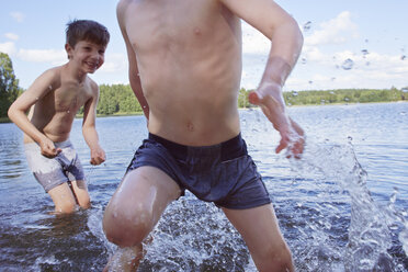 Two young boys playing in lake - CUF35211