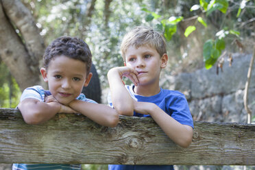 Porträt von zwei Jungen, die sich an einen Gartenzaun lehnen - CUF35252