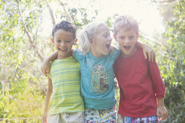 Three children in garden with arms around each other - CUF35254