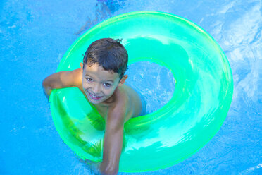 Porträt eines Jungen in einem aufblasbaren Ring im Gartenschwimmbad - CUF35272