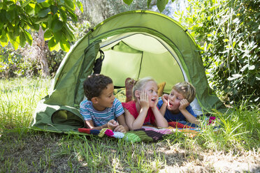 Three children chatting in garden tent - CUF35276