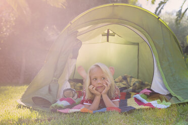 Portrait of girl lying gazing from garden tent - CUF35278