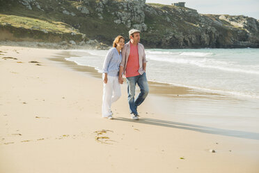 Mature couple holding hands strolling on beach, Camaret-sur-mer, Brittany, France - CUF35370