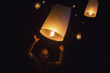 Porträt eines Jungen, der in der Silvesternacht chinesische Laternen loslässt, Krabi, Thailand, Südostasien - CUF35374