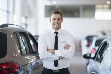 Portrait of smiling salesman in car dealership - CUF35734