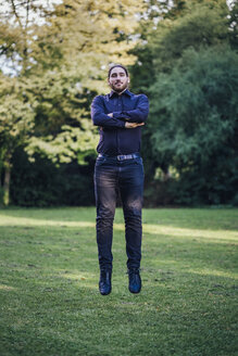 Young businessman levitating in park - JSCF00105