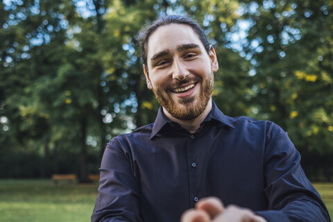 Young businessman greeting business partner in a park, negotiating business transactions stock photo