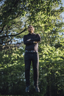 Young businessman levitating in park - JSCF00109