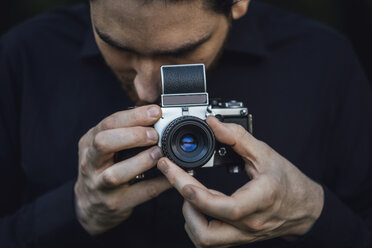 Junger Mann beim Fotografieren mit analoger Kamera - JSCF00110