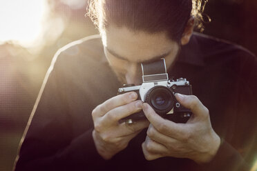 Junger Mann beim Fotografieren mit analoger Kamera - JSCF00111