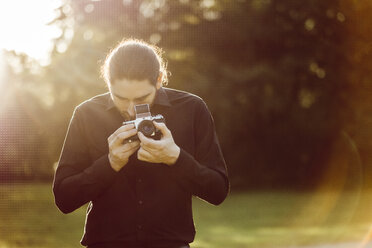 Junger Mann beim Fotografieren mit analoger Kamera - JSCF00112