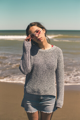 Spanien, Porträt einer jungen Frau mit Sonnenbrille am Strand, lizenzfreies Stockfoto