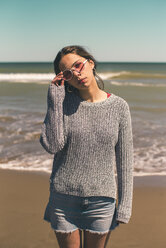 Spanien, Porträt einer jungen Frau mit Sonnenbrille am Strand - ACPF00050