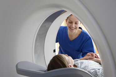 Röntgenassistentin lächelt Mädchen im CT-Scanner an - CUF35999
