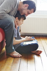 Father and son using digital tablet - CUF36150