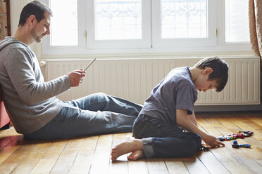 Father and son spending time in living room - CUF36153